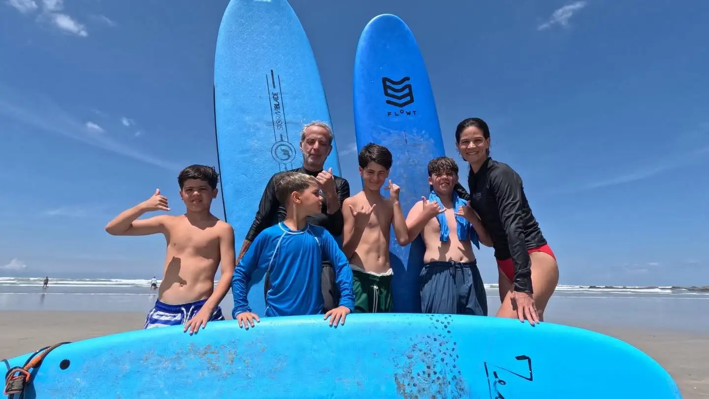 Group of kids posing with surfboards at the beach